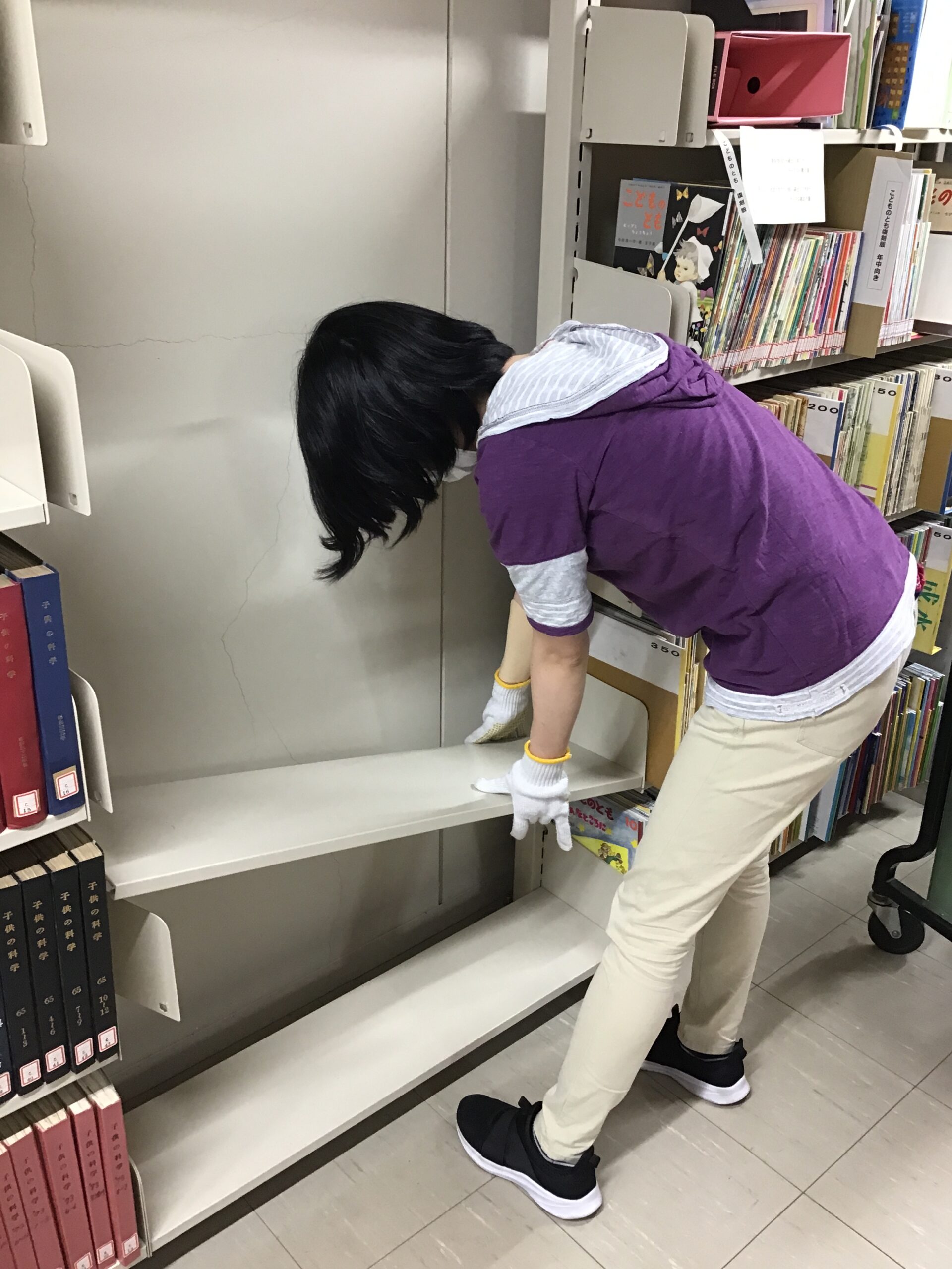 書架の組み替え作業を行う職員の写真