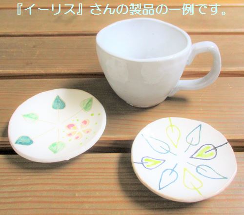 『イーリス』さんの製品である、花や葉っぱがデザインされた陶器の小皿とカップの写真です。