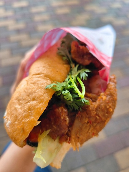 ベトナム料理店「REN」の、松本市出張販売の様子。フランスパンに肉と野菜をサンドした料理バインミーの写真。